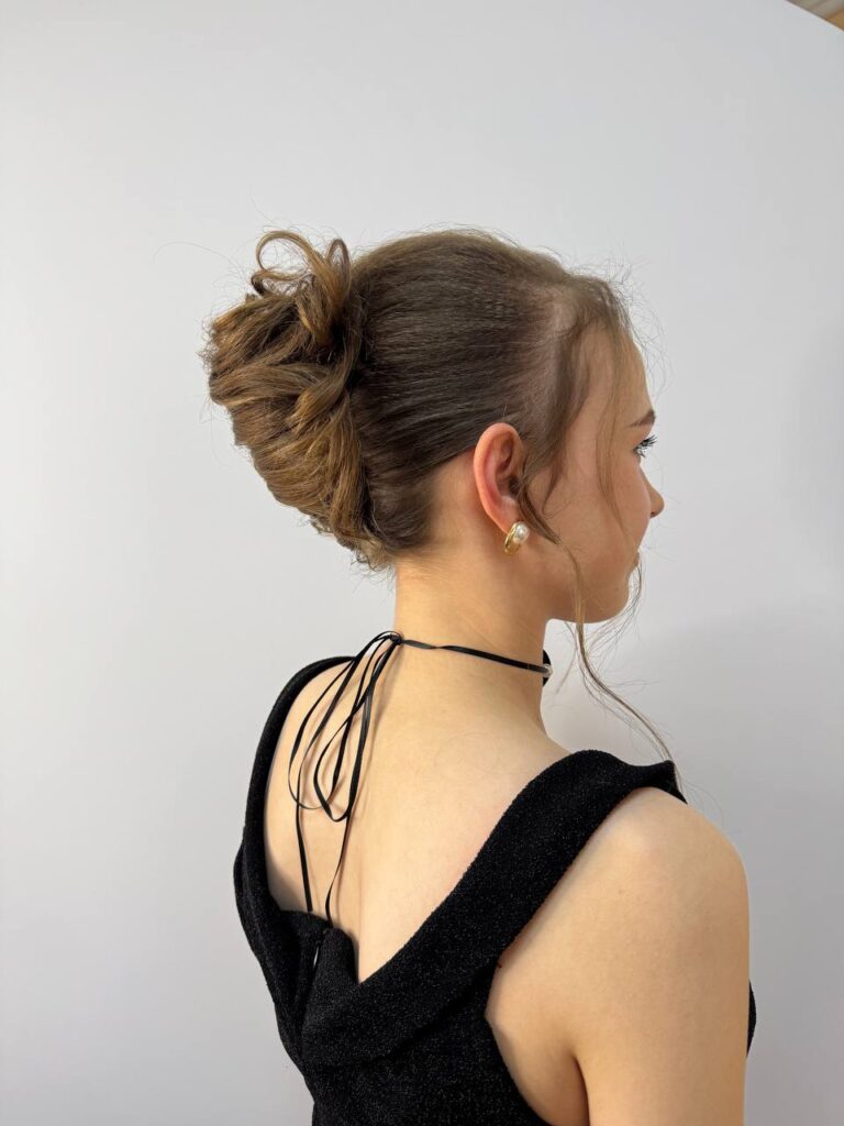 Студентка групи 31 ЛПКСОП демонструє модельну зачіску на захисті